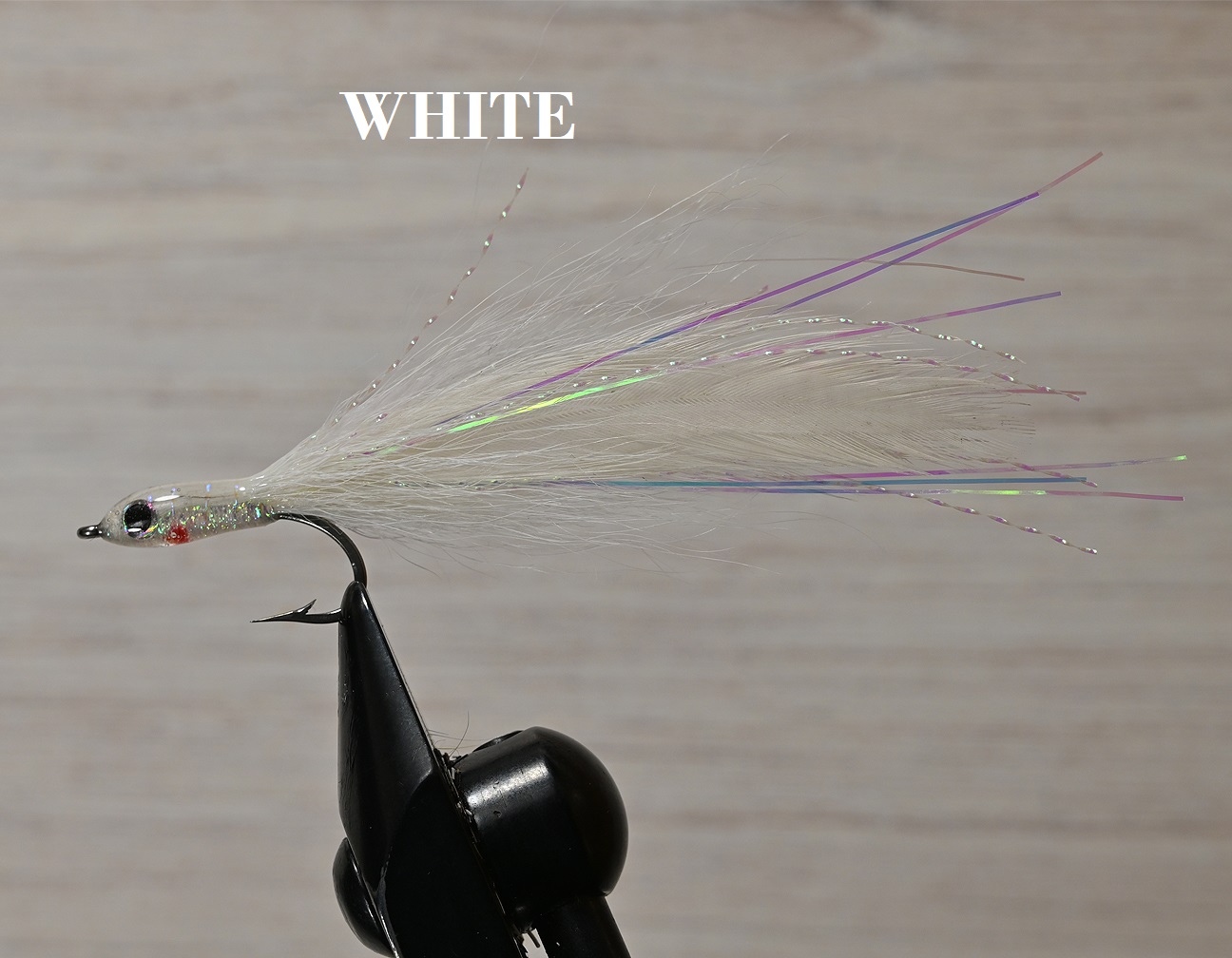Close-up of a white fishing fly lure with iridescent fibers.