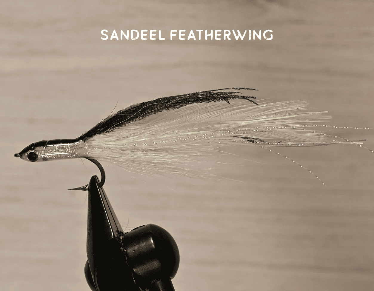 Close-up of a handcrafted Sandeel Featherwing fishing fly on a vise.